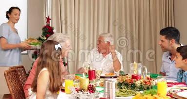 骄傲的母亲带着烤火鸡到圣诞餐桌上